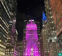 a tall building lit up in pink at night